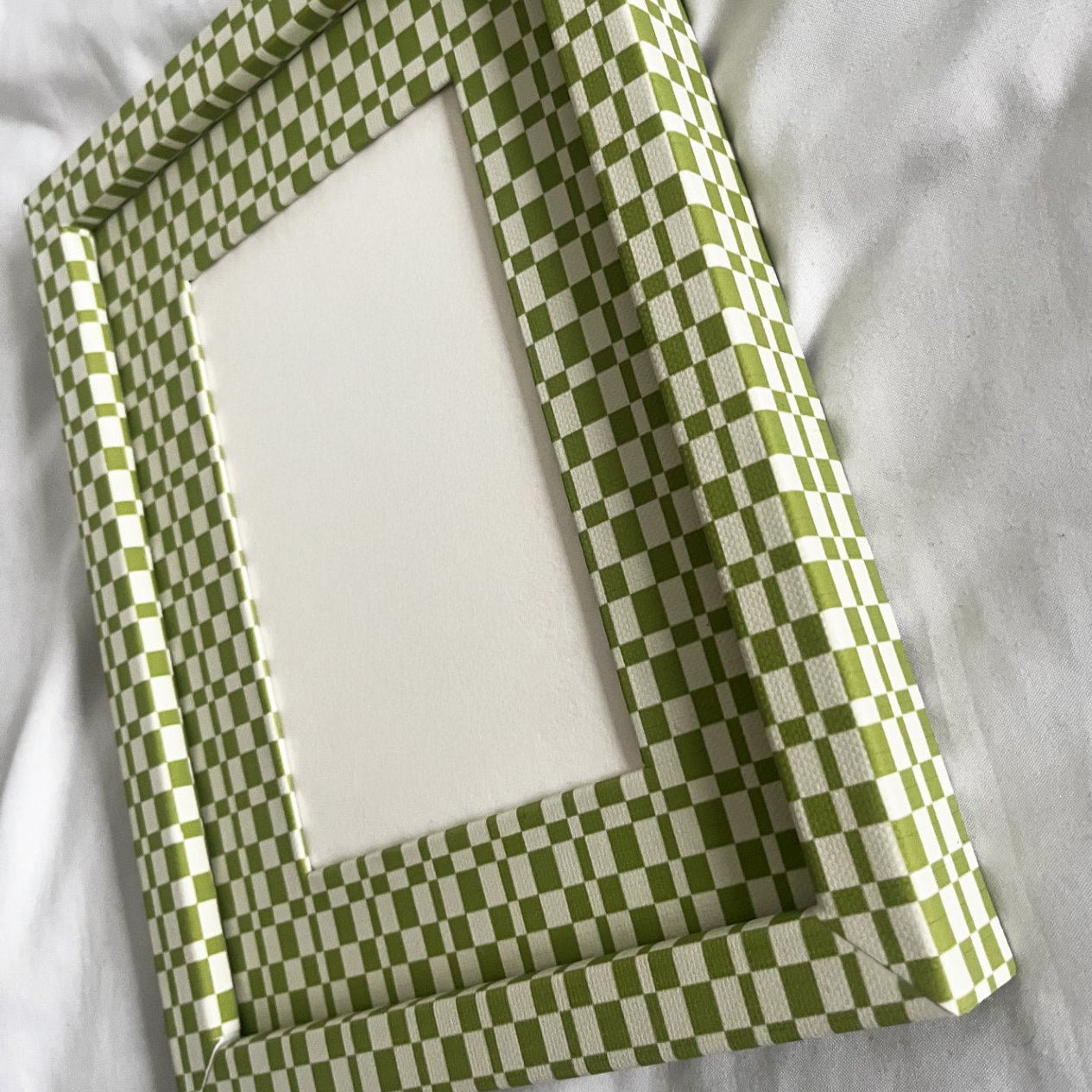 Green checkered fabric folded over a white surface