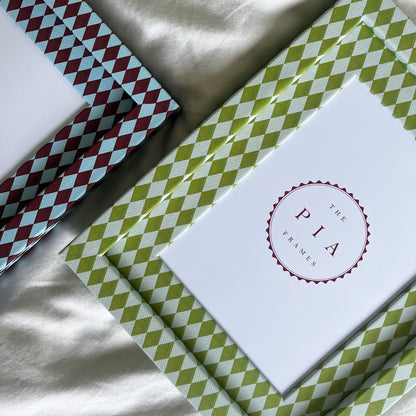 Set of two harlequin fabric frames arranged on a white linen background 