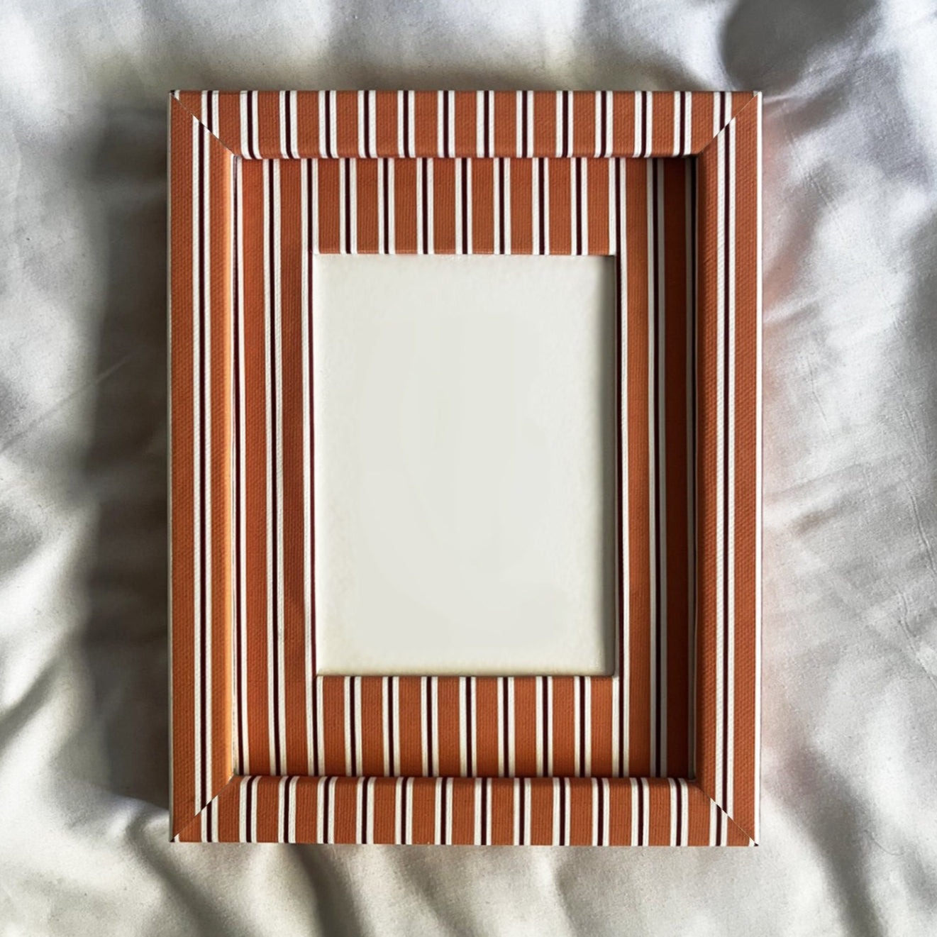 Rectangular wooden picture frame on a textured white background