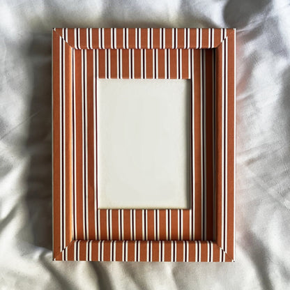 Rectangular wooden picture frame on a textured white background
