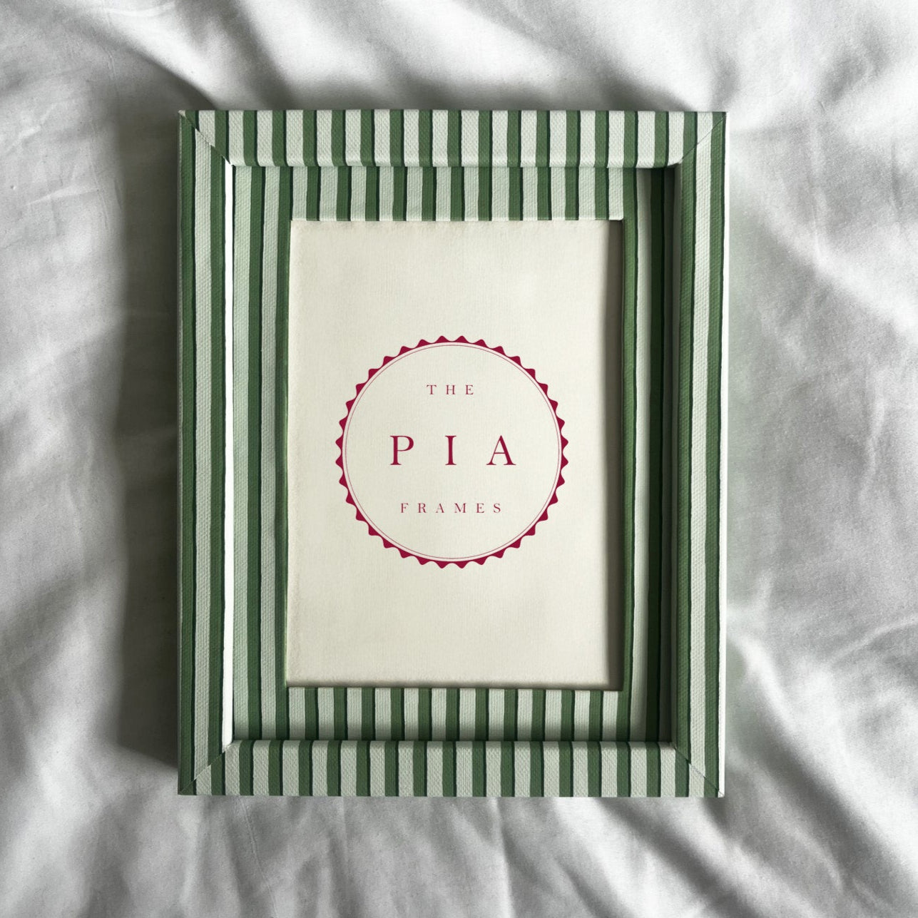 Green and white striped picture frame with 'The Pia Frames' logo on a light background