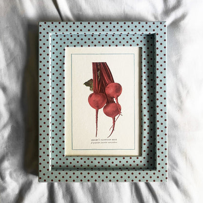 Framed botanical print of red beets on a white surface