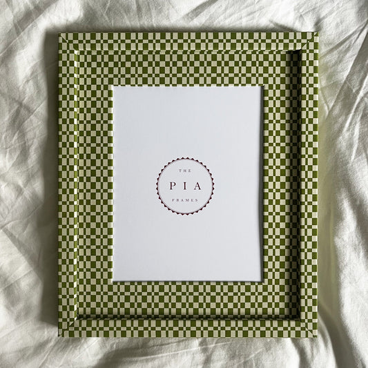 Green checkered frame with a white center on a white fabric background