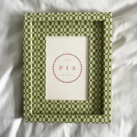 Green checkered frame with a white center on a white fabric background