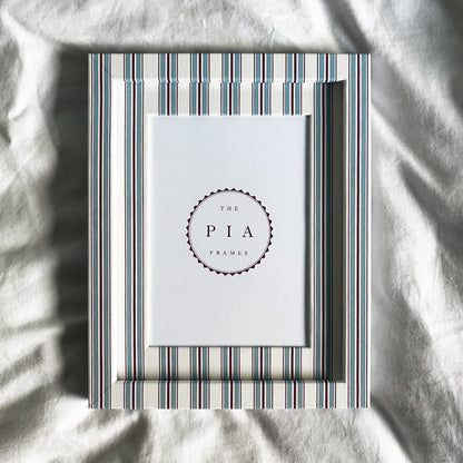 hand made blue and red striped picture frame on a white linen background