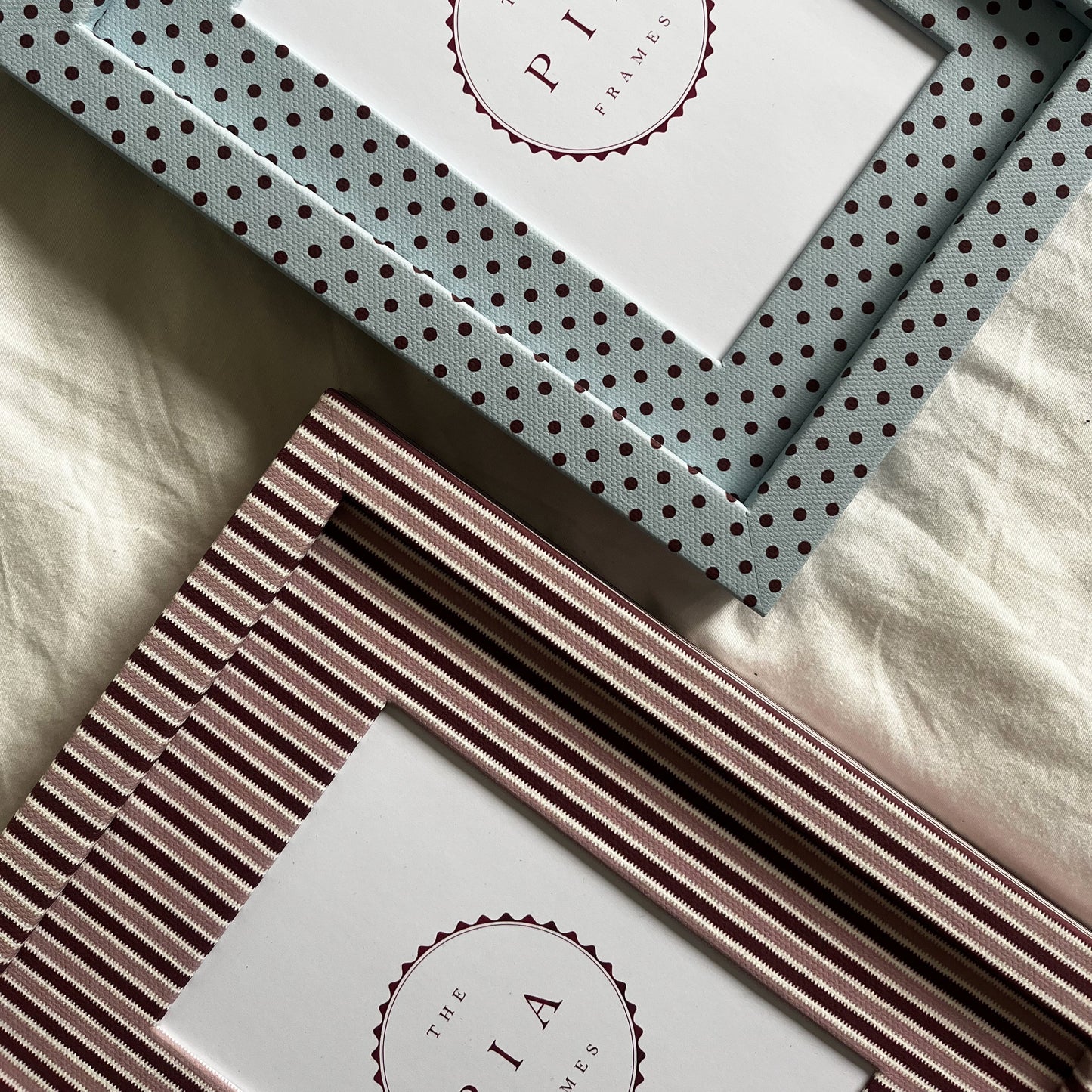Set of blush and burgundy zigzag and polka dot picture frames arranged on fabric