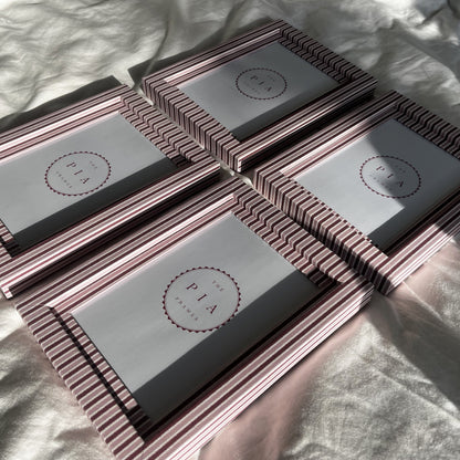 Blush and burgundy zigzag picture frames grouped together on fabric in sunlight, highlighting unique patterns