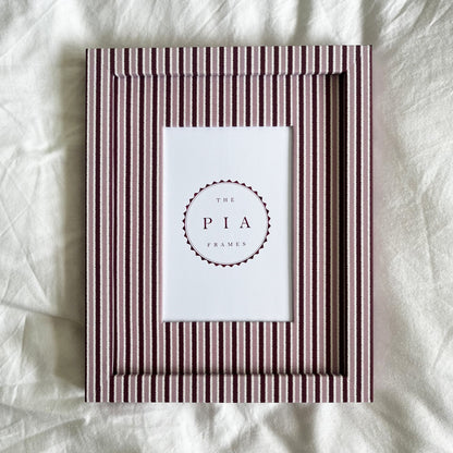 Pink and burgundy striped photo frame on white linen background