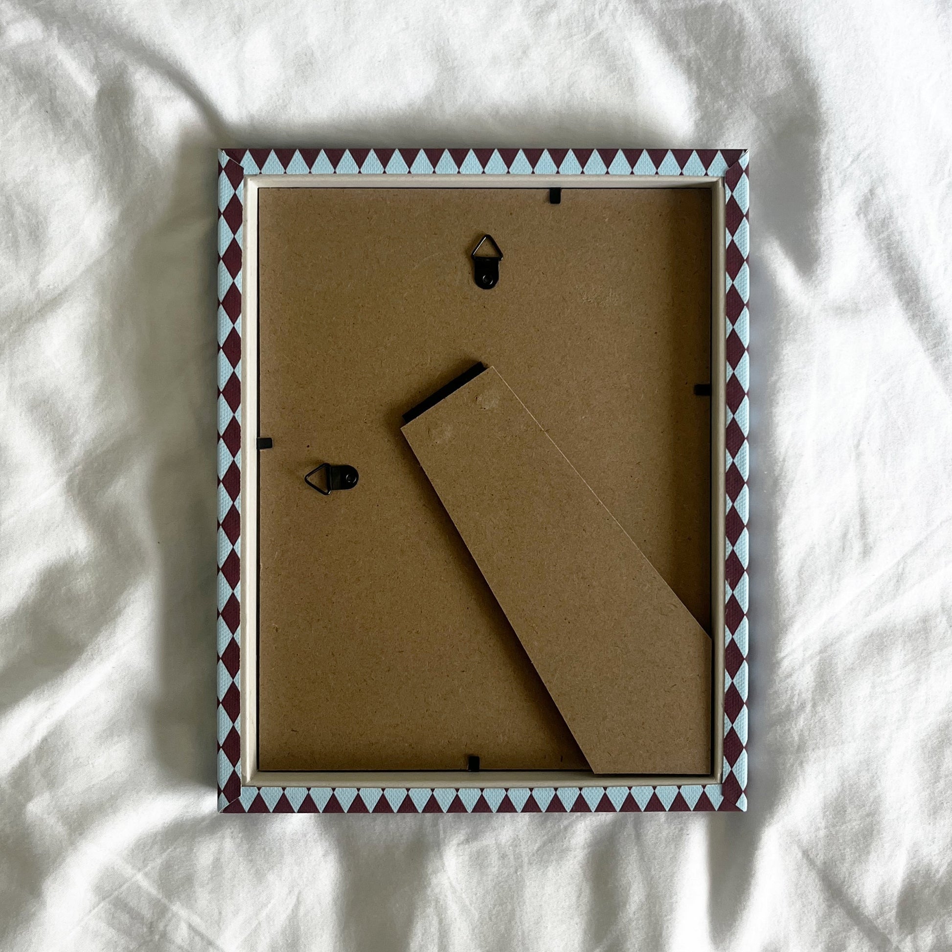 back view of a handmade geometric fabric photo frame showcasing wall fittings and frame structure