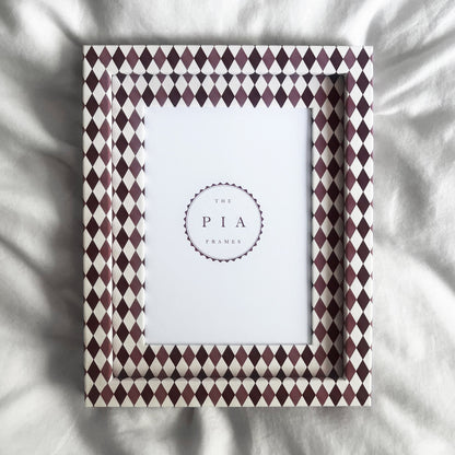 Handmade burgundy, blush and white harlequin fabric frame, on a white linen fabric