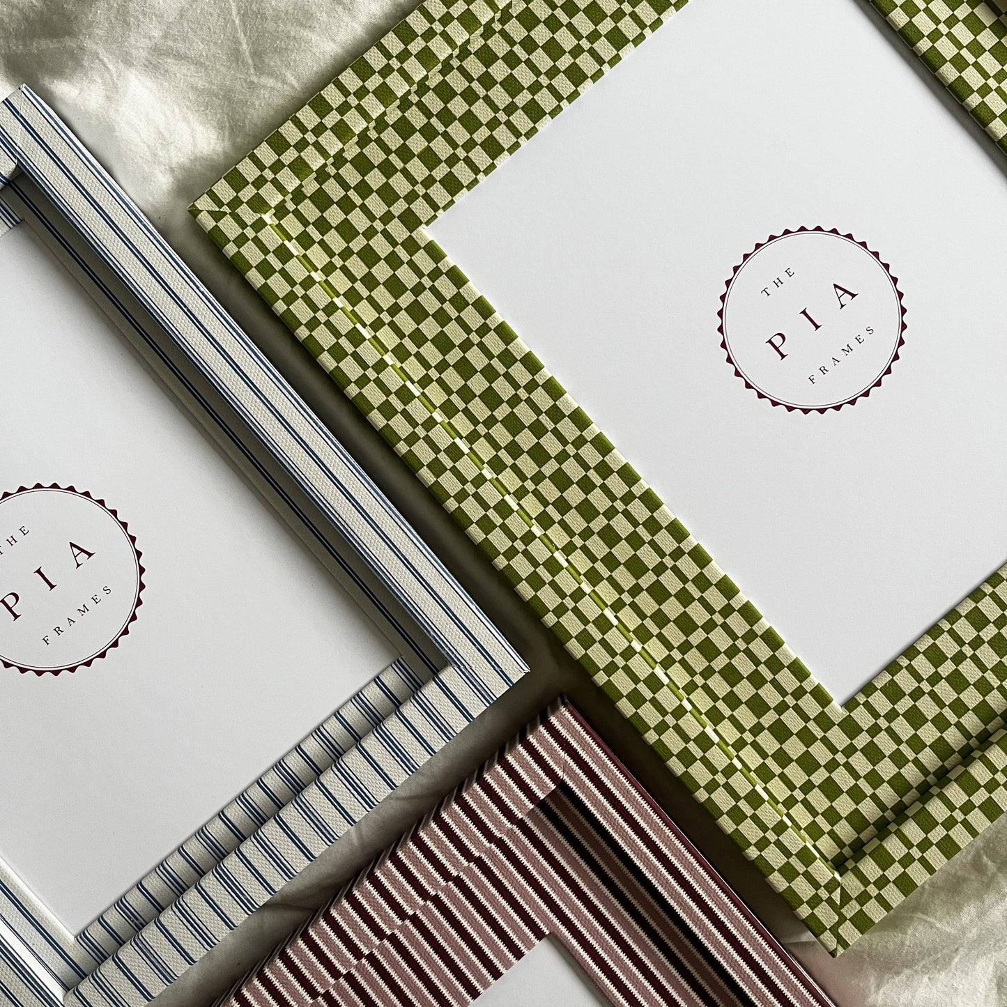 Set of three handmade colourful fabric picture frames on a white fabric background