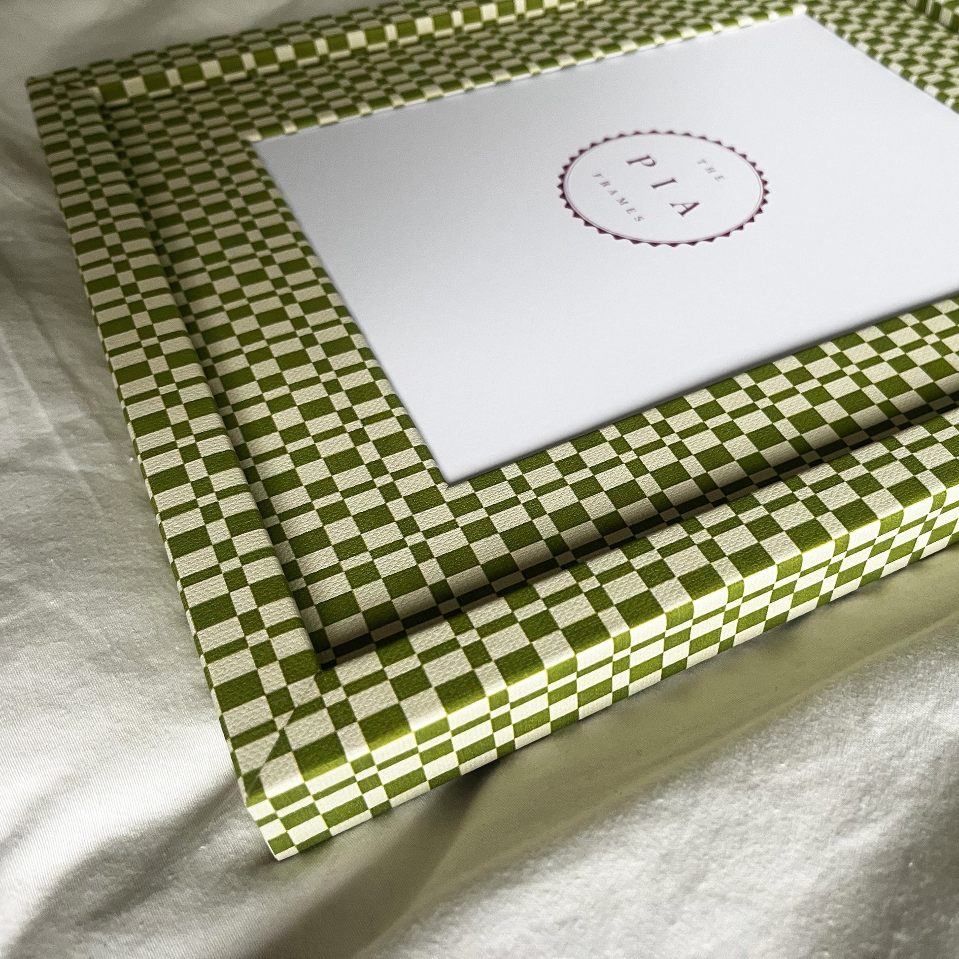 Angled side view of handmade green and beige checkered picture frame, showcasing its design and depth
