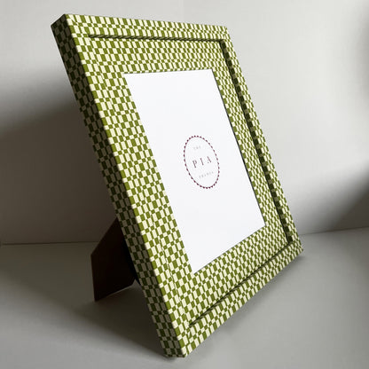 Handmade green and beige checkered picture frame standing on a stand, showcasing its design and depth