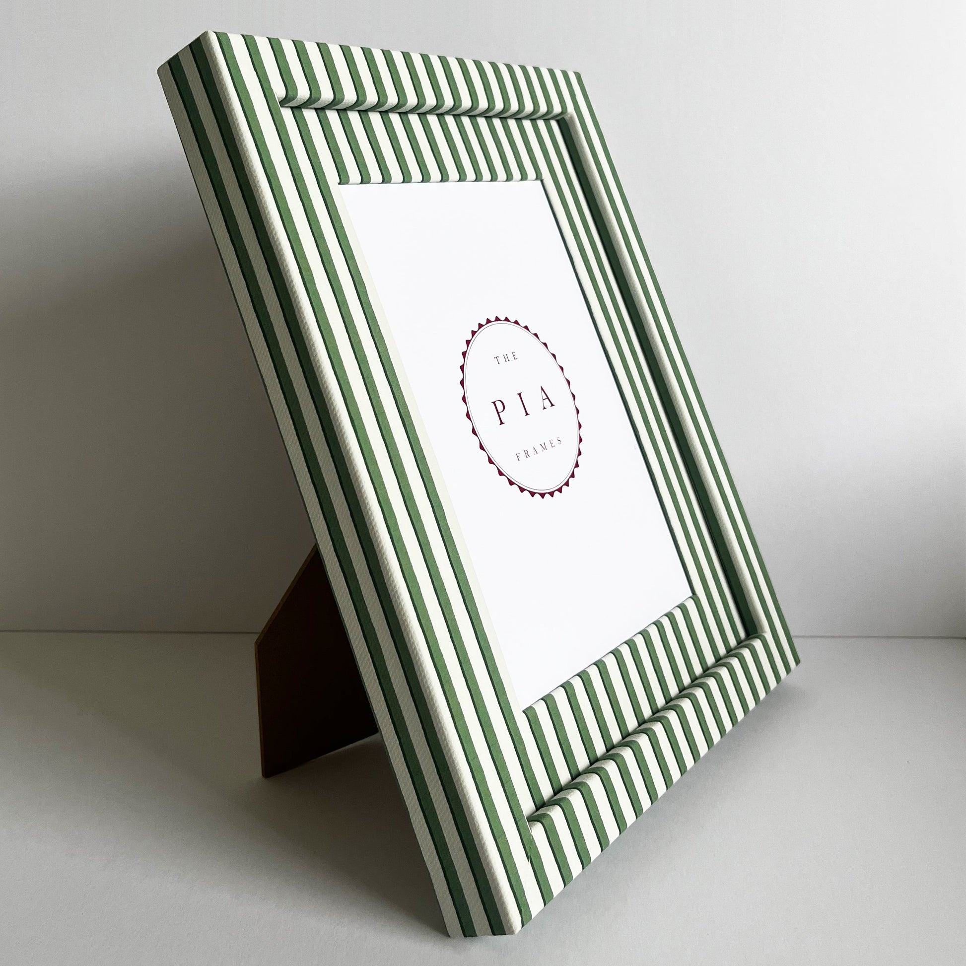 Handmade green vanguard stripe picture frame standing on a stand, showcasing the frame’s design and depth