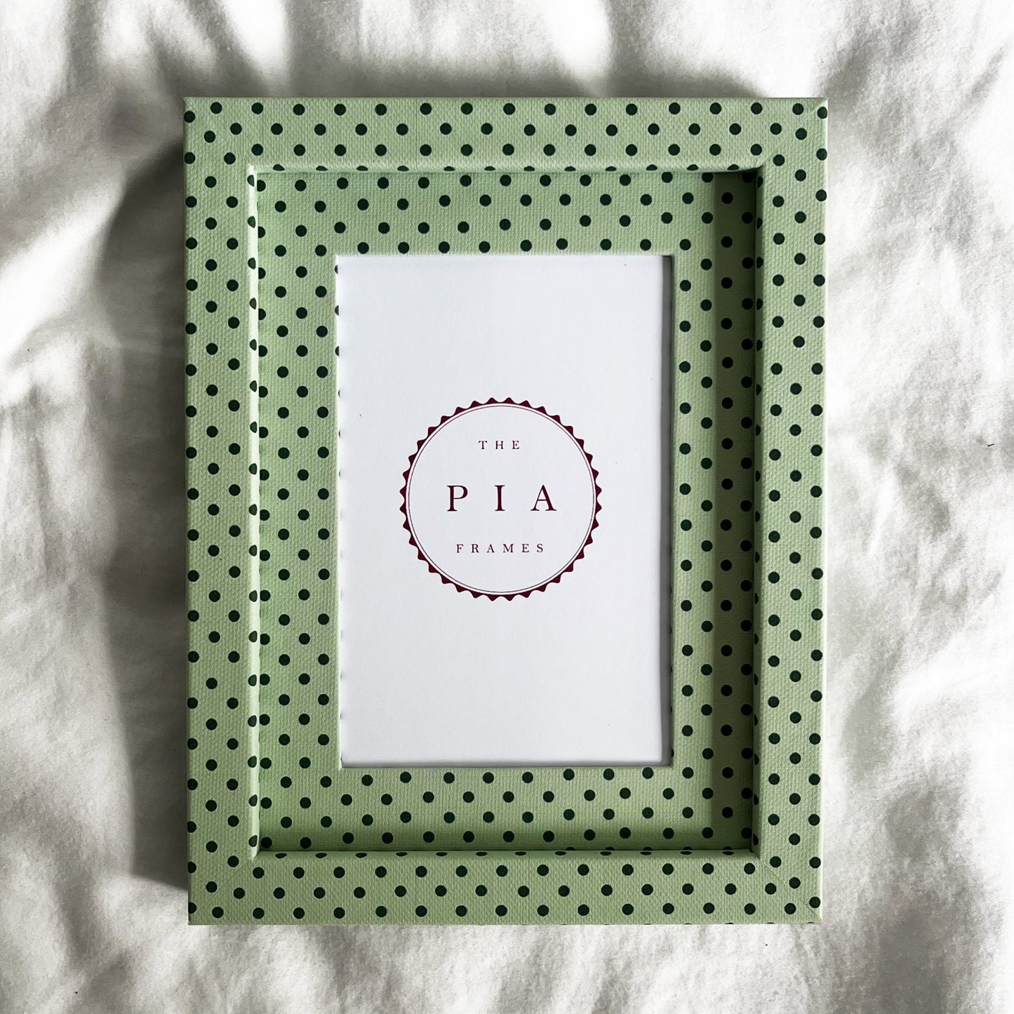 Full view of handmade mint and jade Pembroke polka dot picture frame on a neutral background