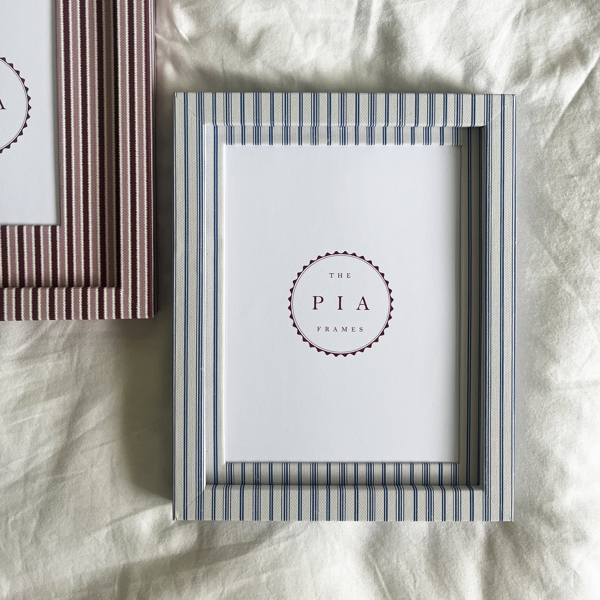 Pairing of handmade rustic stripe and blue burgundy zigzag picture frames on a neutral background