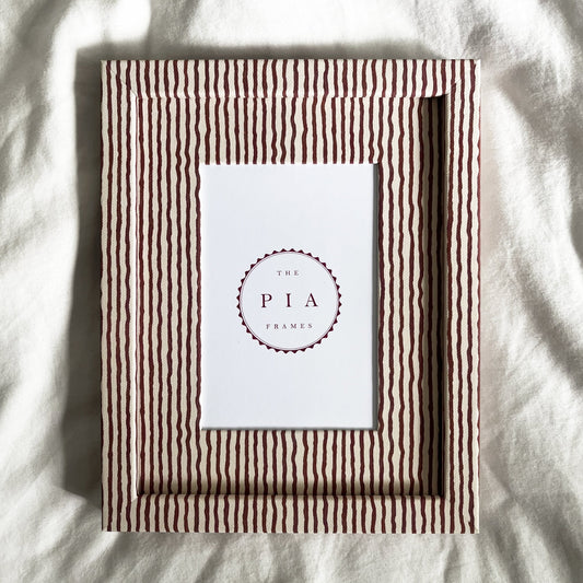 Terracotta and beige striped picture frame on a white linen background