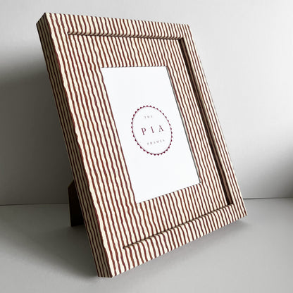 Angled view of stranding striped photo frame against white background 