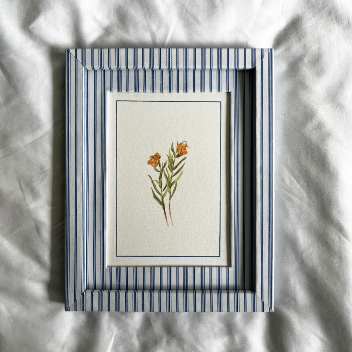 Full view of Lilium Columbianum orange wildflower botanical print in 10x8 inch Rustic Blue Stripe frame on linen background