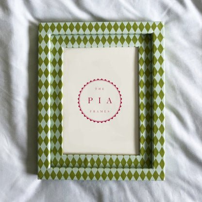 Green patterned frame on a white fabric background
