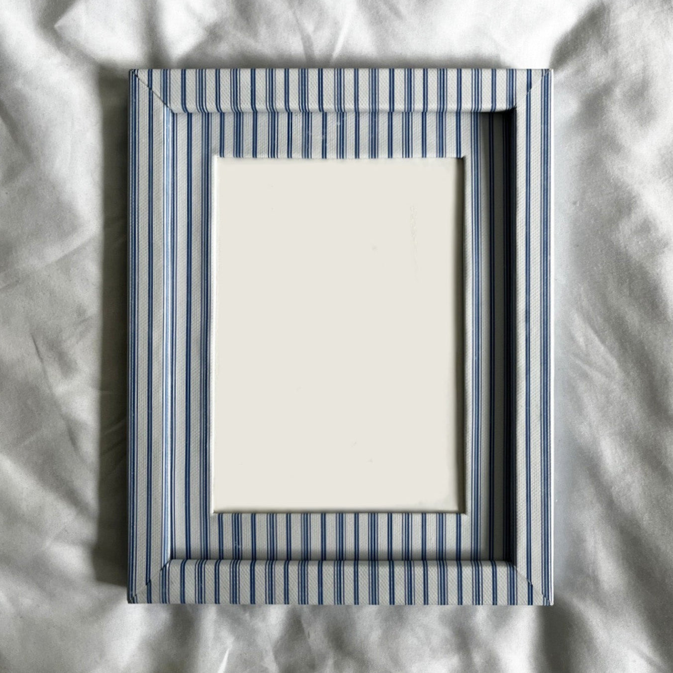 Striped picture frame on a textured white surface