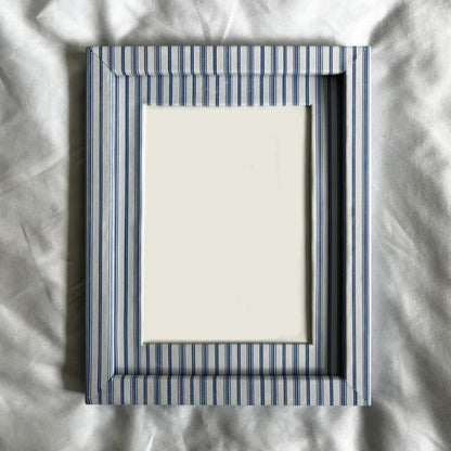 Striped picture frame on a textured white surface