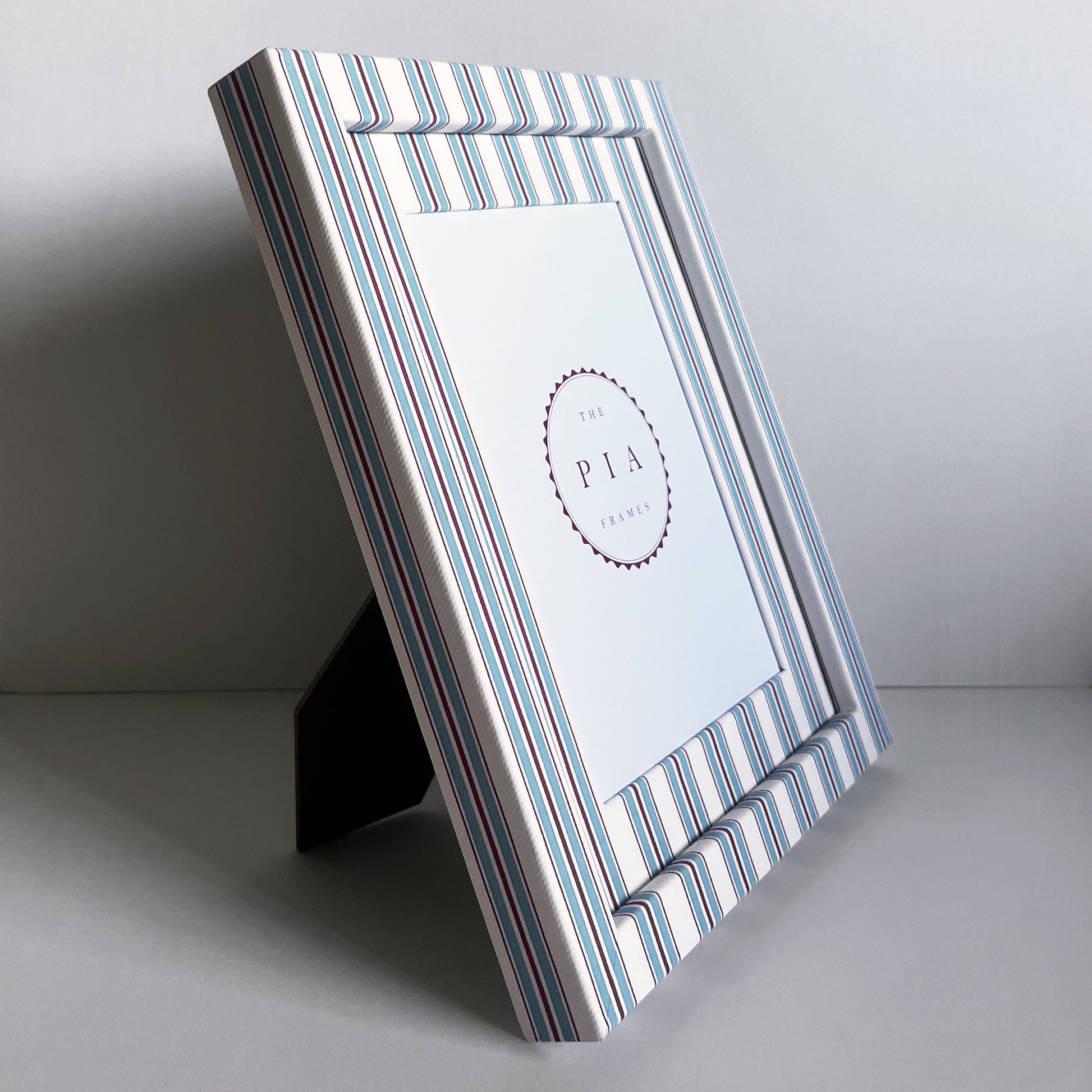 side view of hand made blue and red striped picture frame on white background